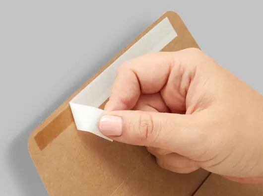 Close-up of peel and seal release tape strip on a kraft paper mailer bag